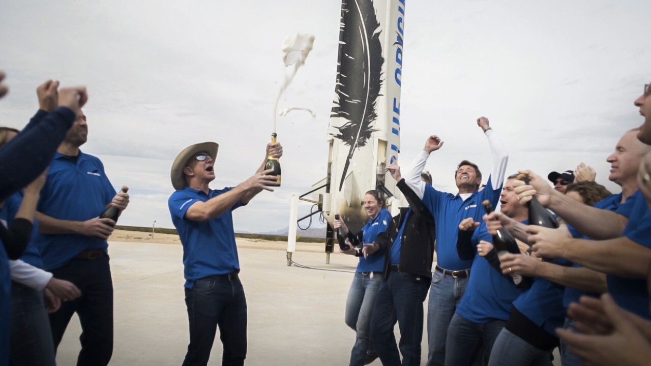 Blue Origin founder Jeff Bezos and three passengers react to the historic launch aboard the New Shepard.